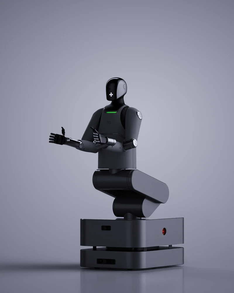 MARK One seated on its base in a soft grey studio, one hand raised